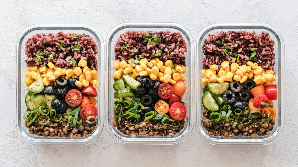 Boîtes en verre de meal prep : riz, maïs, olives, tomates et lentilles